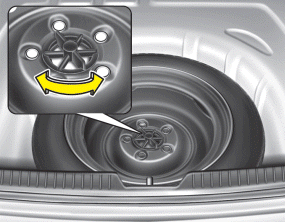 Turn the tire hold-down wing bolt counterclockwise.